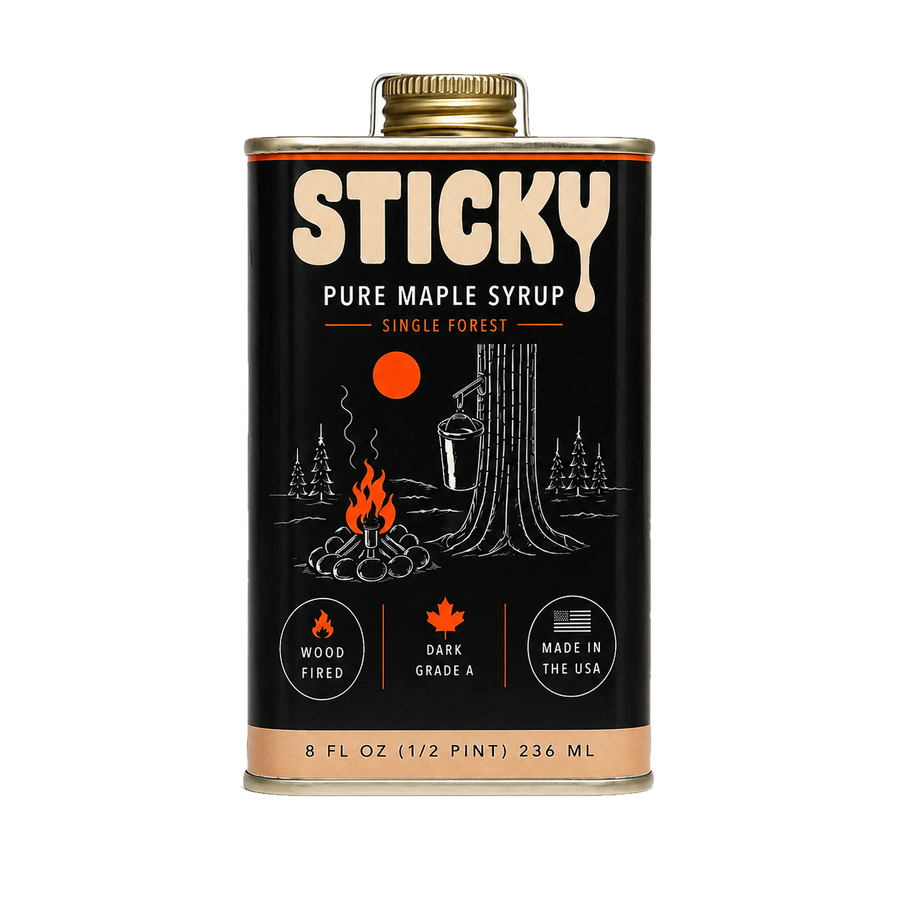 Black 8 oz tin of Sticky Dark maple syrup with a gold cap, cream logo, drawn campfire and maple tree
